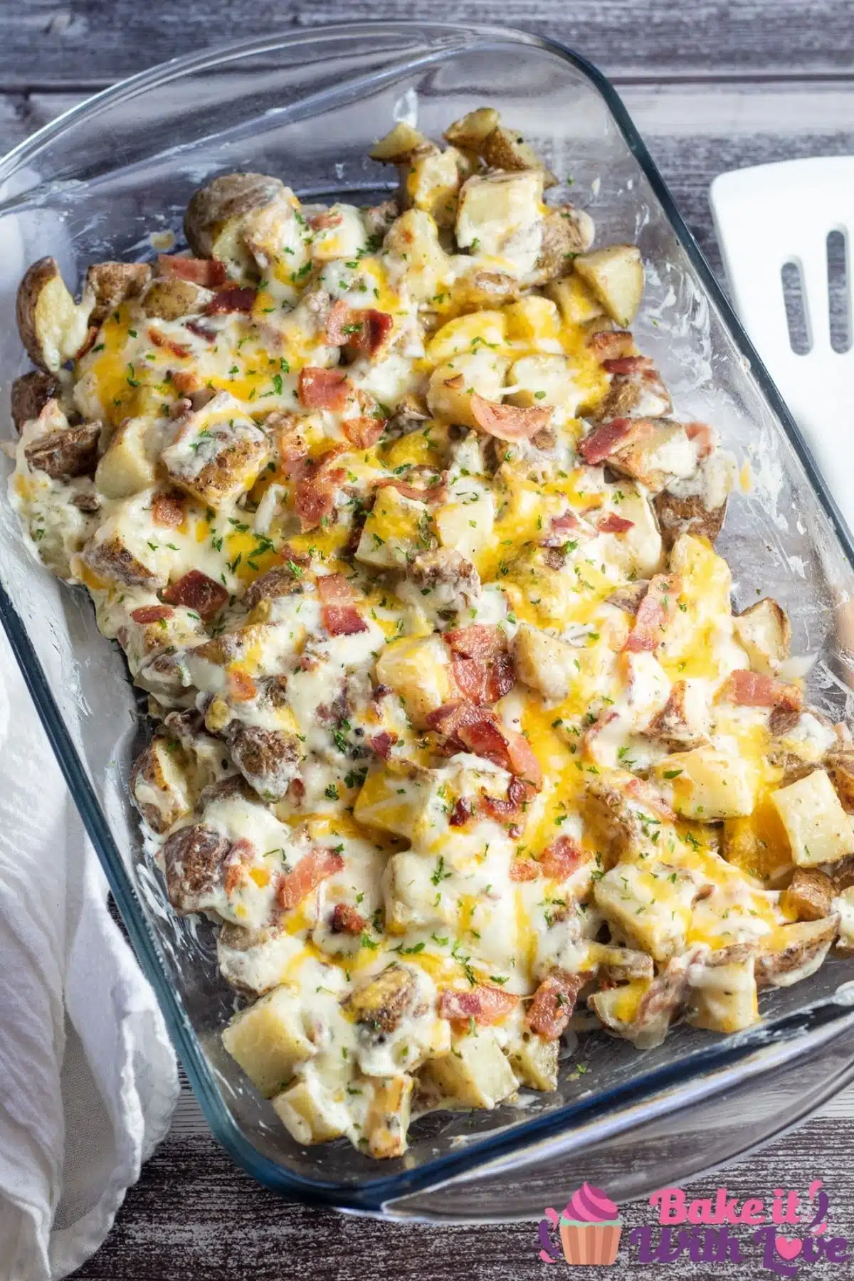 Tall image of cheesy bacon ranch potatoes in a 9x13 dish..