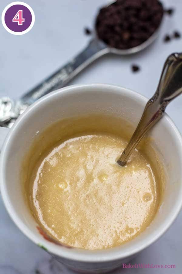 Chocolate chip mug cake process photo 4 showing the wet and dry ingredients mixed together to make the cake batter in a coffee cup.