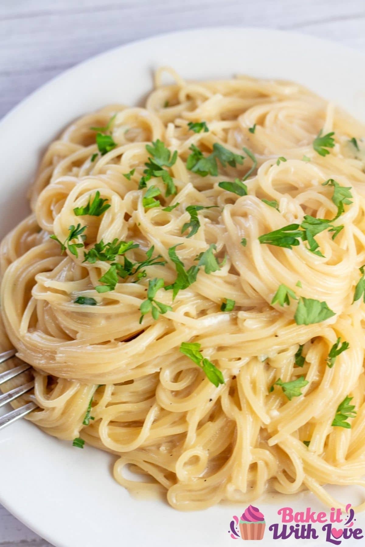 Tall photo of garlic Parmesan angel hair pasta on white plate.