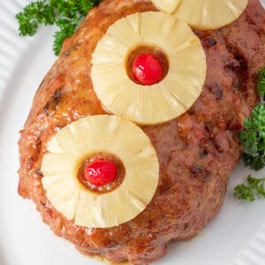 Square image of ham loaf on a white plate.