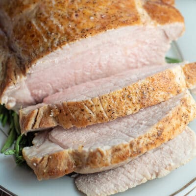 Square image of sliced pork loin on a cutting board.