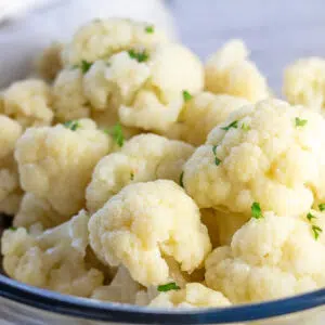 Square image showing cauliflower in a glass bowl.