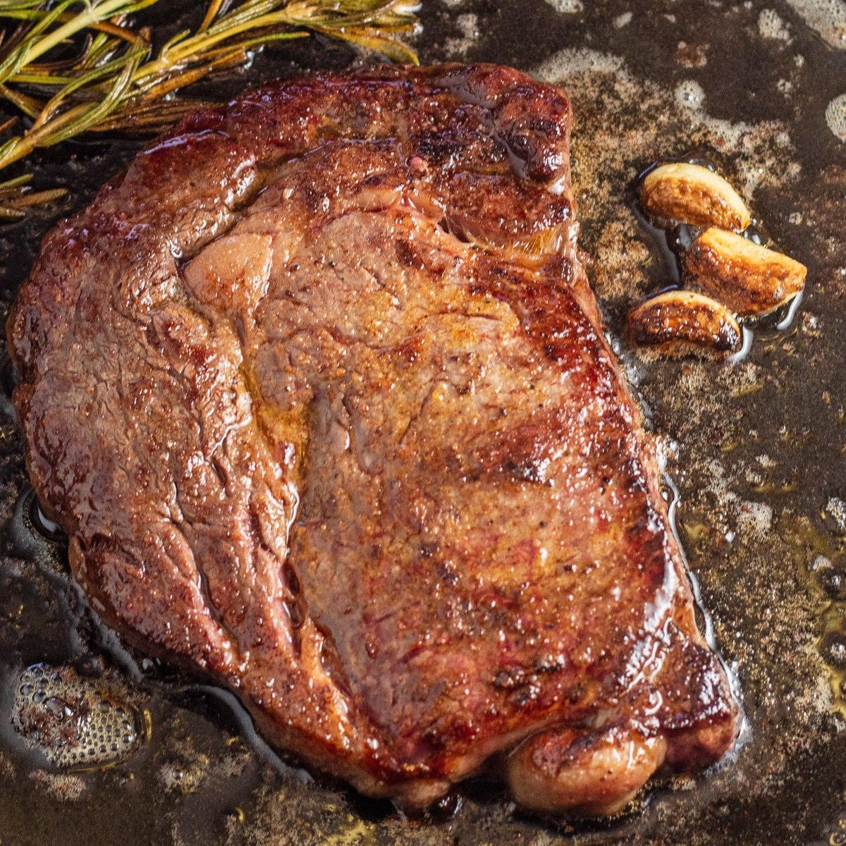 Foto persegi steak wagyu dalam wajan.