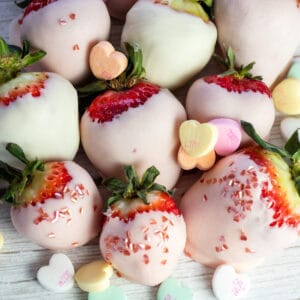 Best pink chocolate covered strawberries with heart decor and conversation hearts.
