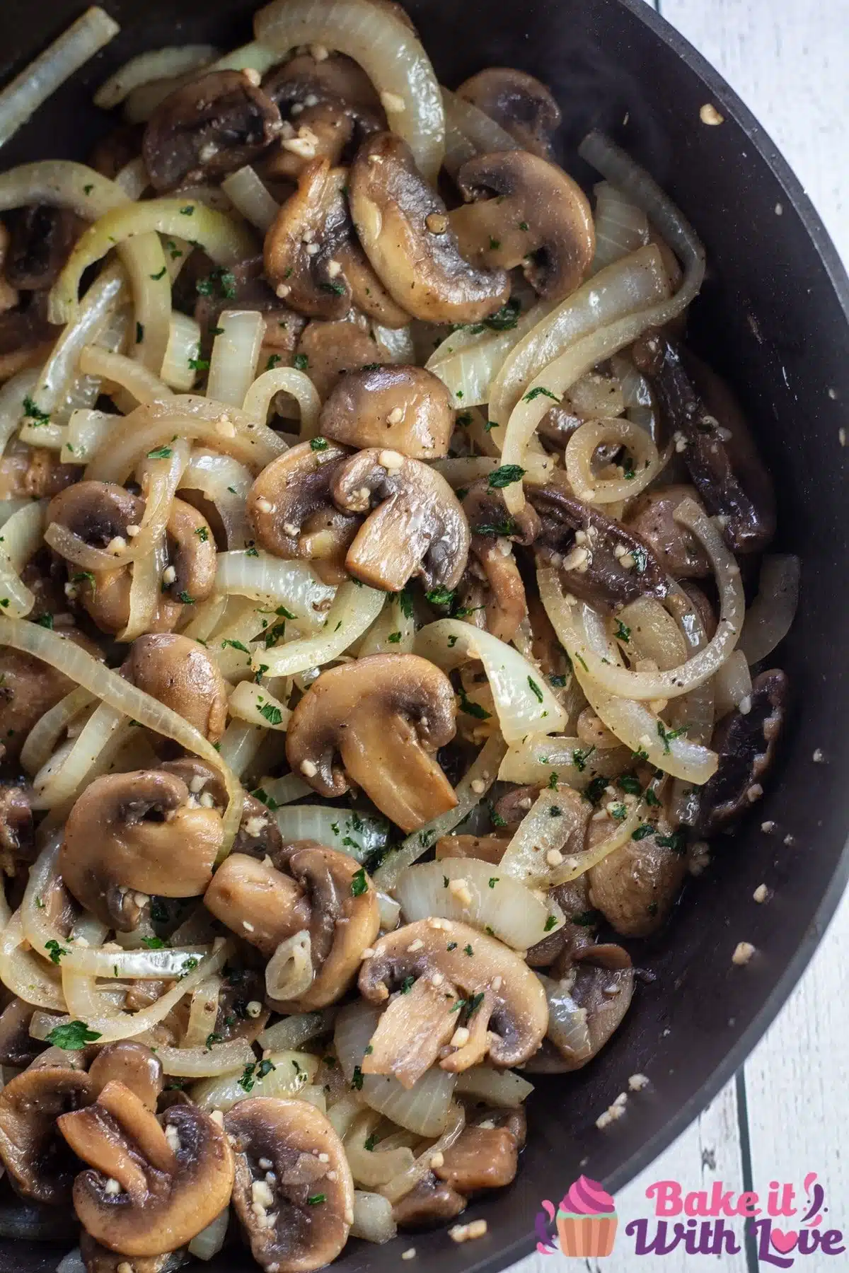 Overhead of the right hand side of skillet with sauteed mushrooms and onions.