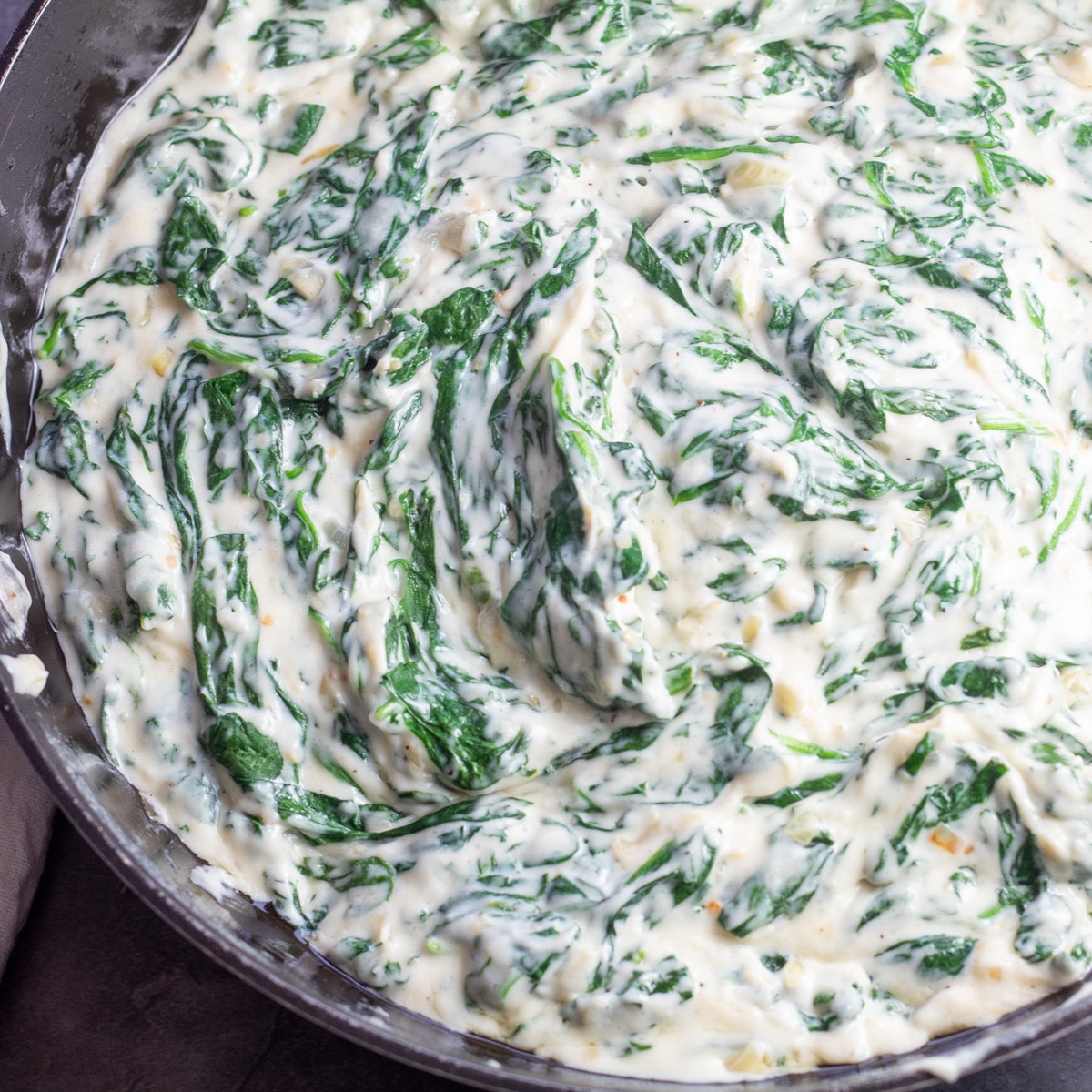 Square image of steakhouse creamed spinach in pan.