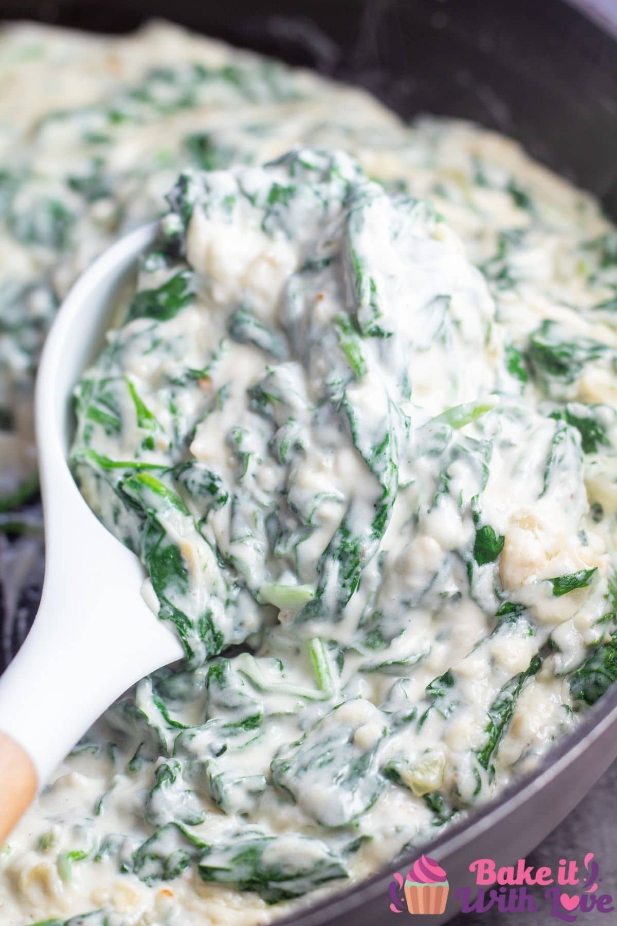 Tall image of steakhouse creamed spinach in pan.