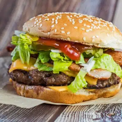 What to serve with burgers, square image of cheeseburger with lettuce.