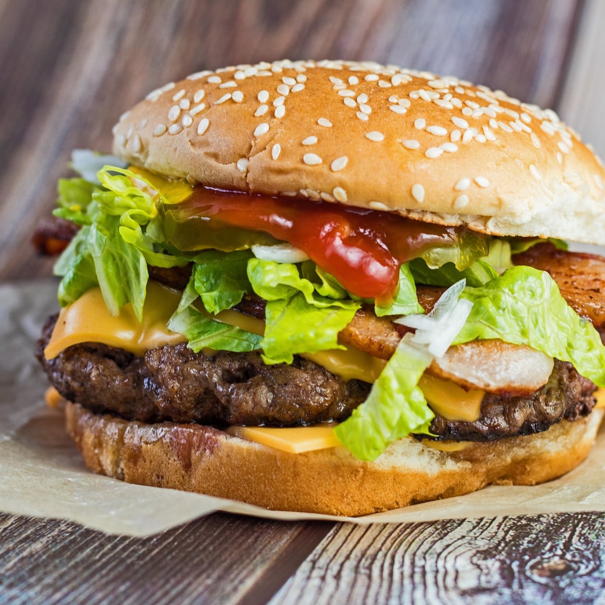 Firkantet billede af cheeseburger med salat.