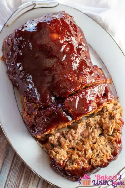 Tall overhead image of the bbq meatloaf on platter with slices cut away.