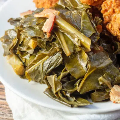 Square image of collard greens on a white plate.