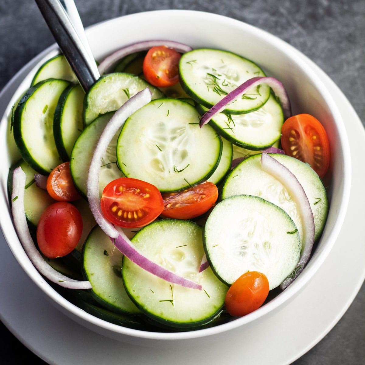 Amazingly tasty cucumber vinegar salad with red onion, cherry tomatoes, and fresh dill.