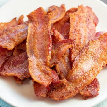 Wide overhead image of the plated air fryer bacon on white plate.