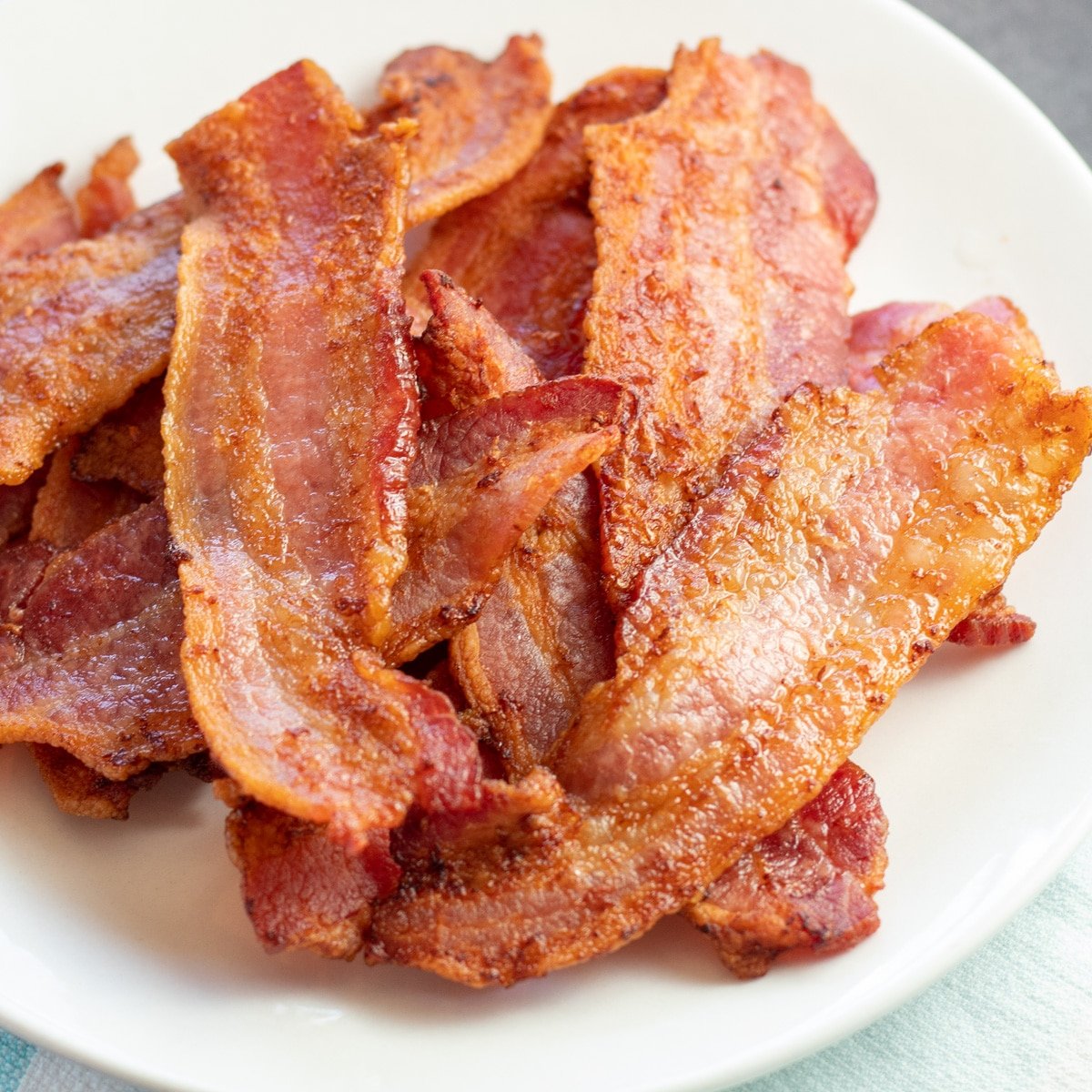 Bacon penggorengan udara yang sangat renyah disajikan di piring kecil.