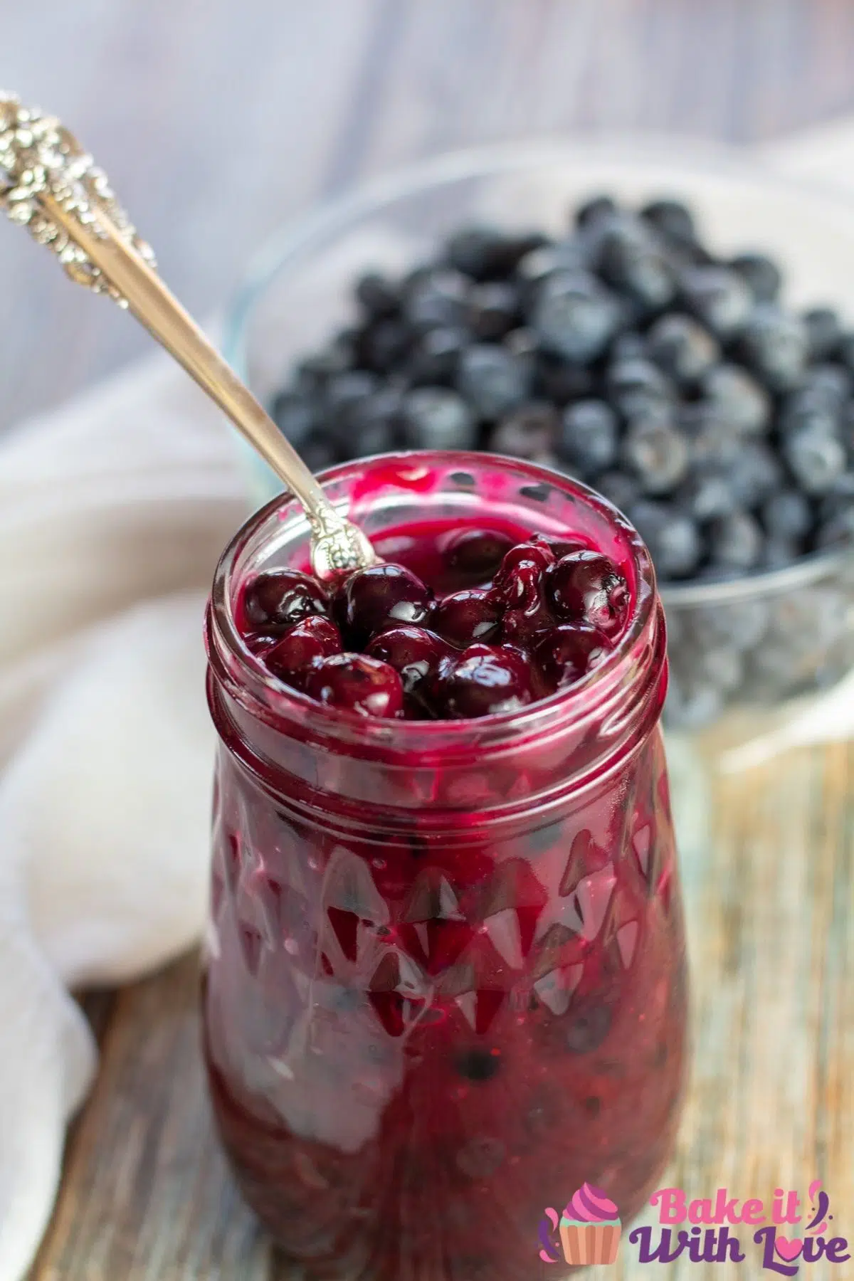 Best homemade blueberry pie filling canned in fluted jar and served with more fresh blueberries.