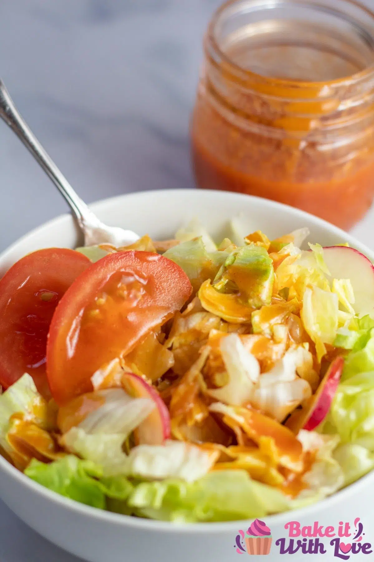 Tall image of salad with catalina dressing.