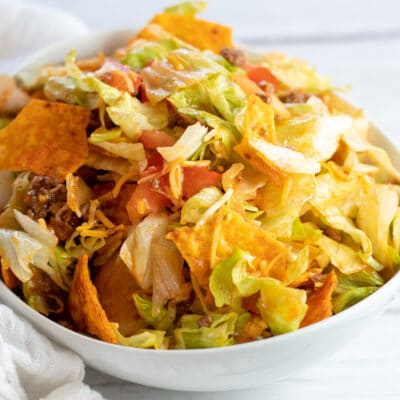 Square image of Doritos taco salad in a white bowl.