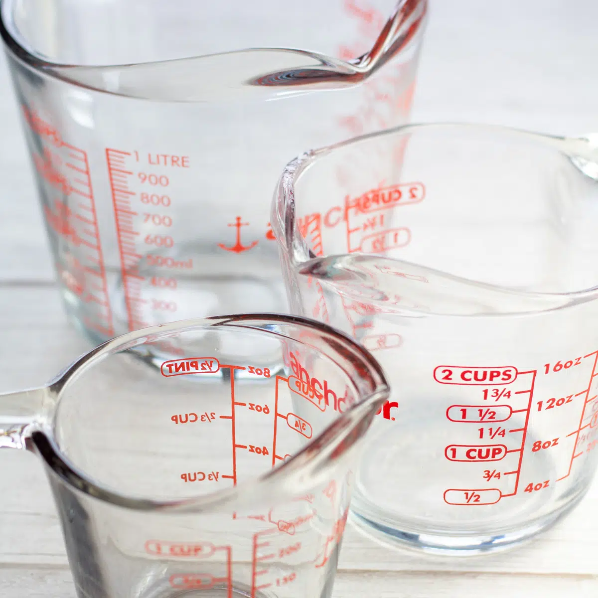 Multiple assorted measuring cups for how many cups in a gallon guide.