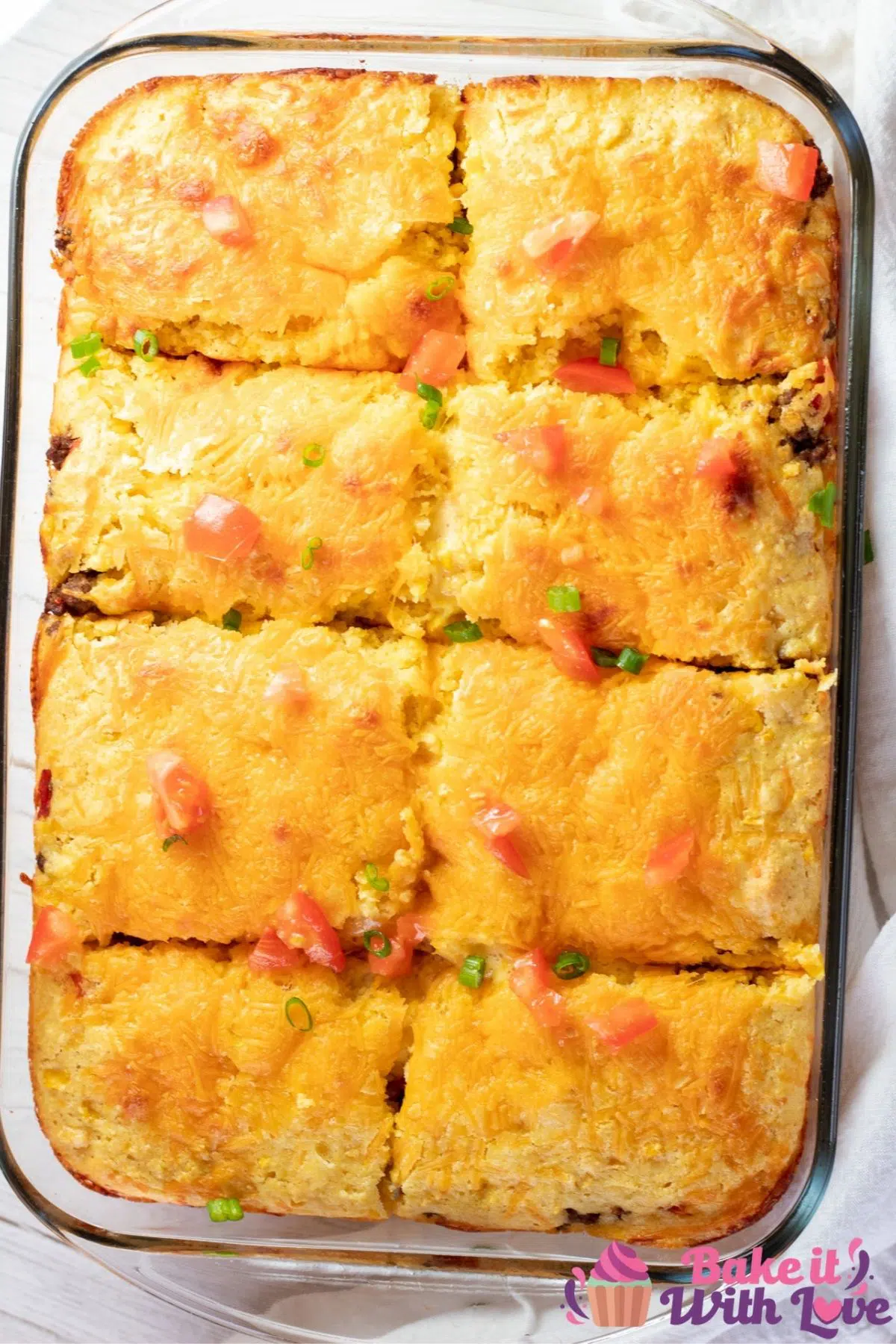 Tall overhead image of the baked Mexican cornbread casserole cut into 8 squares for serving.