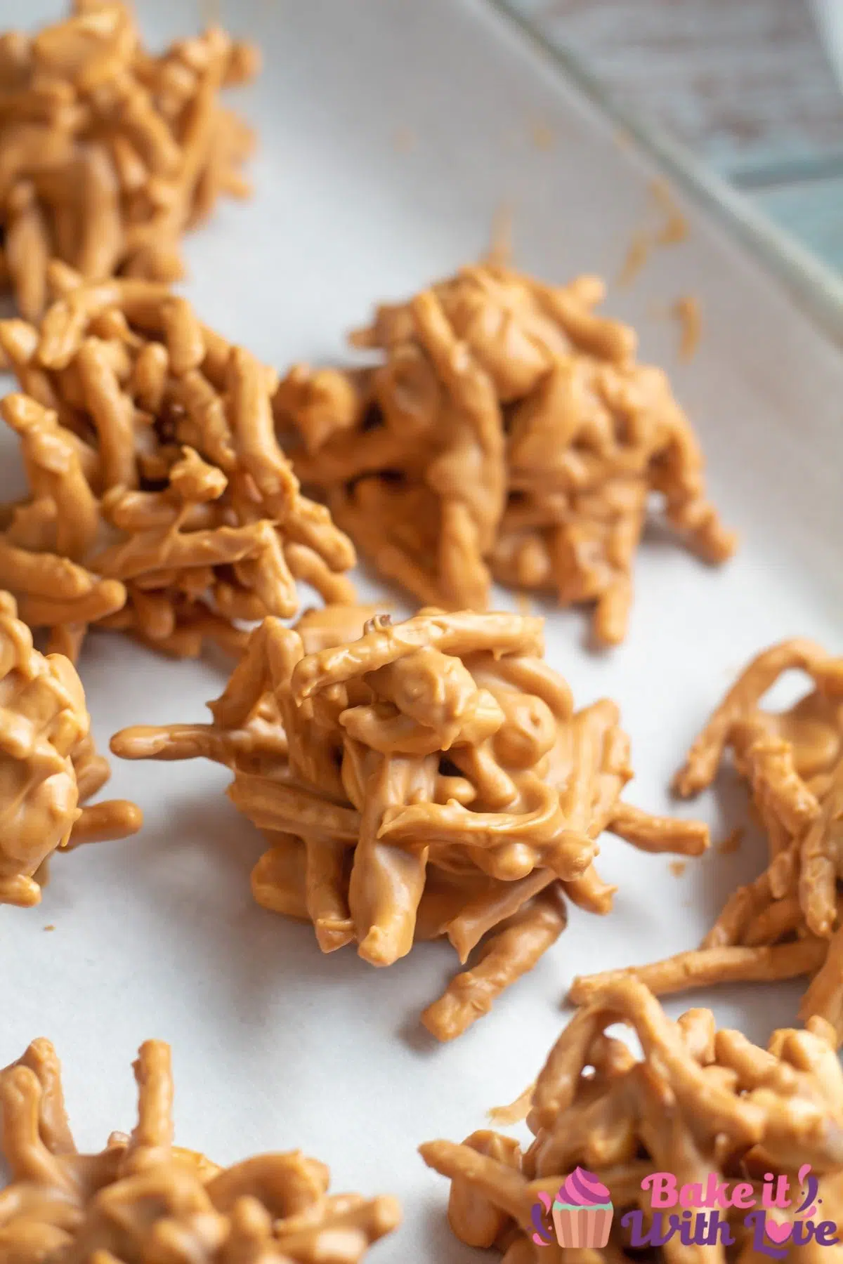 Tall image of the easy no-bake haystack cookies on parchment paper.