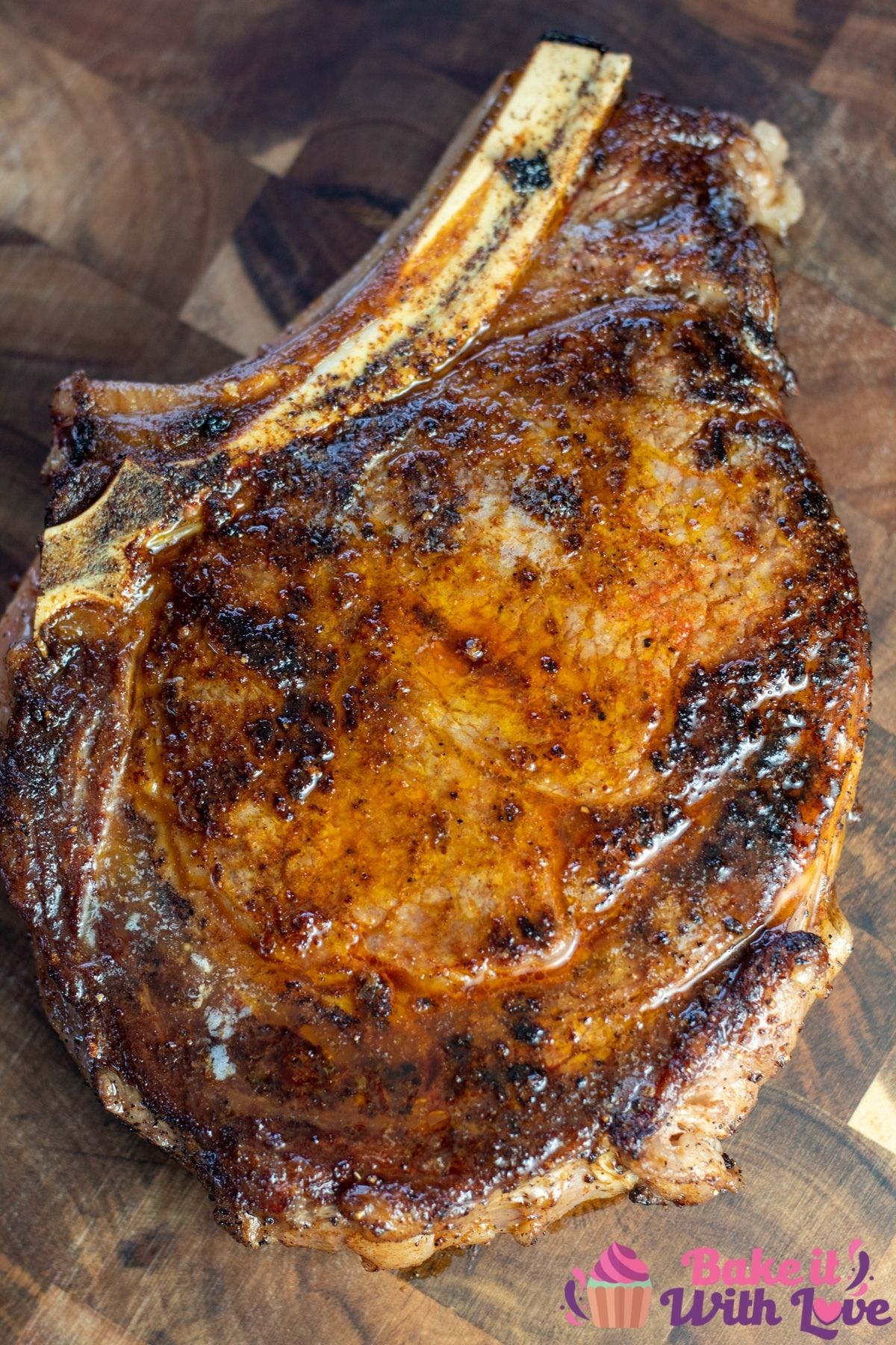 Tall image of the steakhouse style pan seared cowboy ribeye steak on cutting board.