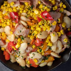 Closeup square image of the best succotash with bacon and butter beans.