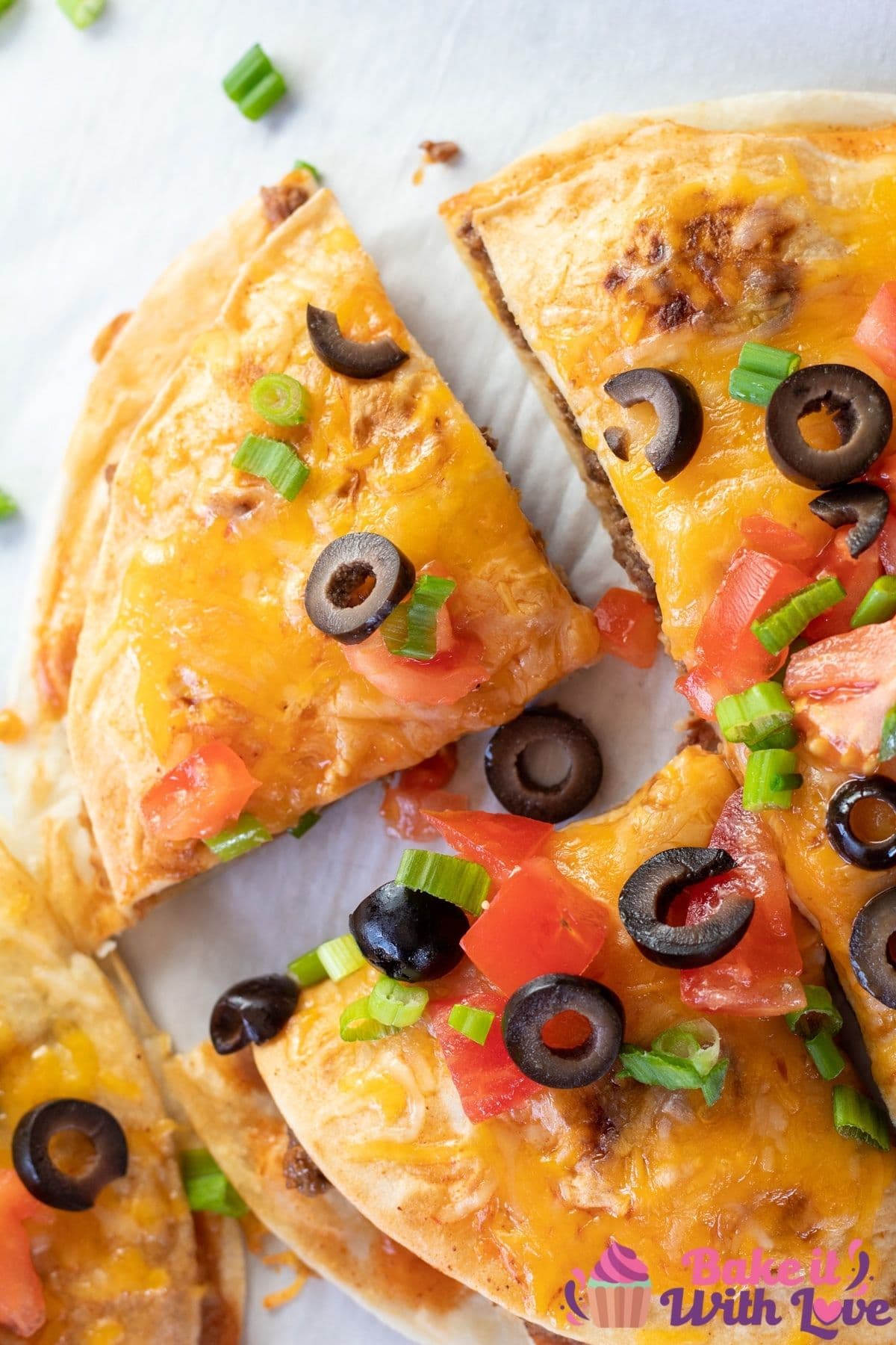 Tall overhead of the quartered Taco bell Mexican pizza with toppings.