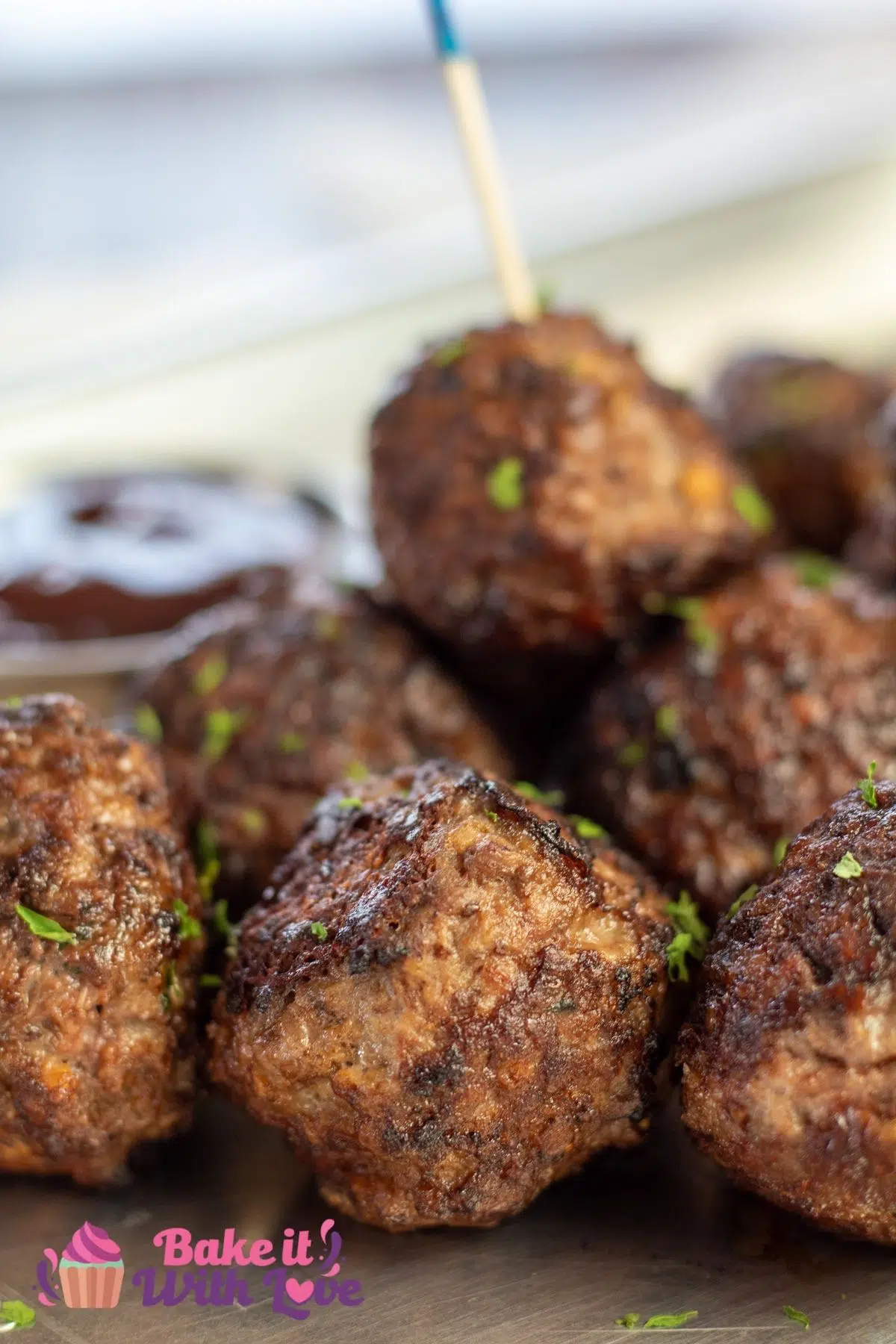 Tall closeup of the best venison meatballs on metal tray with cocktail toothpicks.