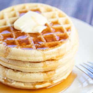 Best air fryer frozen waffles served on white plate with butter and syrup.