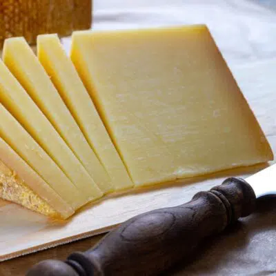 The best gruyere cheese substitute options featuring image of freshly sliced gruyere.