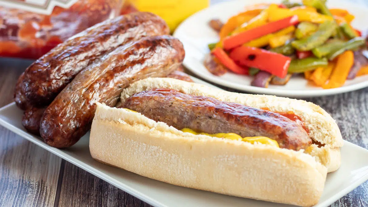 Easy air fryer Italian sausage served with plenty of condiments on wooden background.