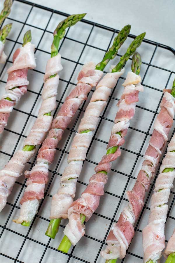 Process photo 4 place bacon wrapped asparagus spears on wire cooling rack.