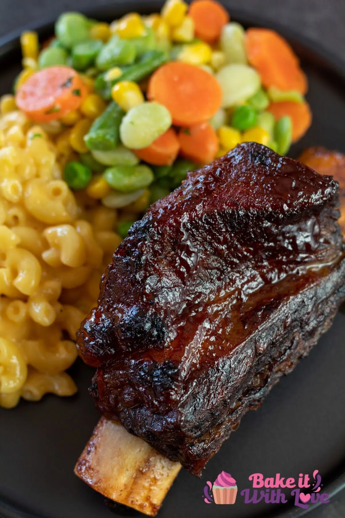 Tall image of baked bbq short ribs plated with mac and cheese.