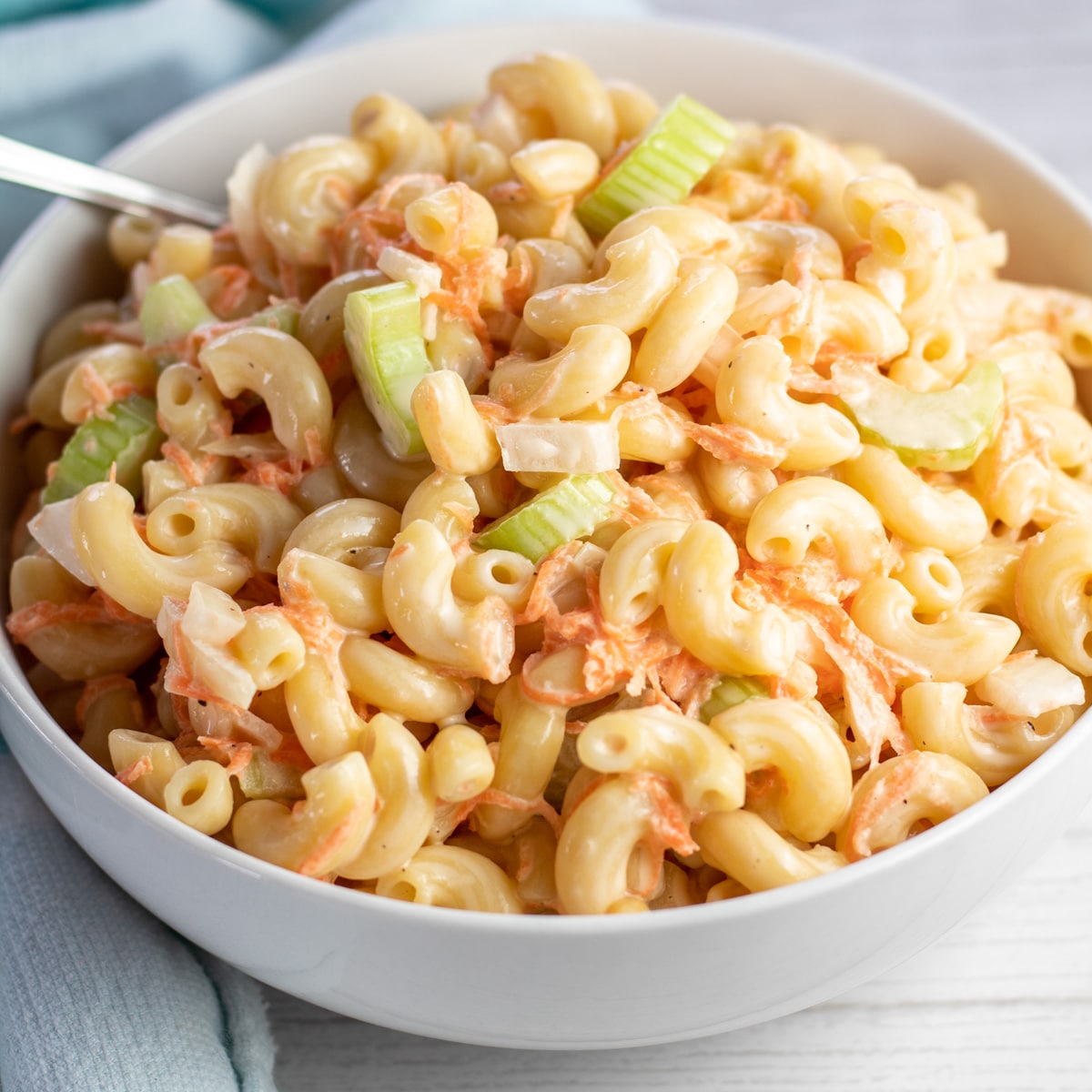 Best Hawaiian macaroni salad served in white bowl on light background.