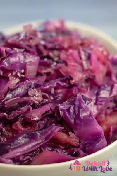 Tall close up image of a white bowl of braised red cabbage.