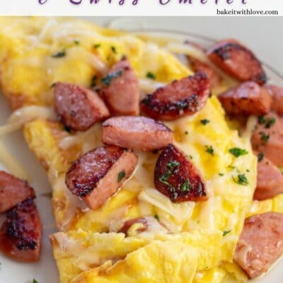 Pin image with text of kielbasa and Swiss cheese omelet on a white plate.