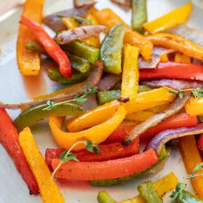 Easy, flavorful roasted peppers and onions served with fresh thyme as garnish.