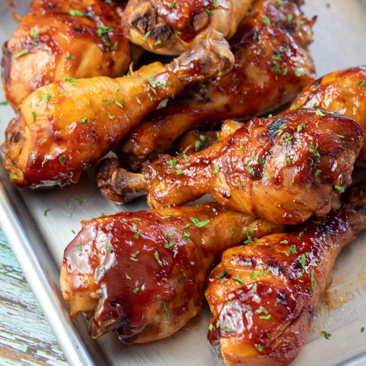 Best slow cooker chicken drumsticks stacked and served with bbq sauce coating.