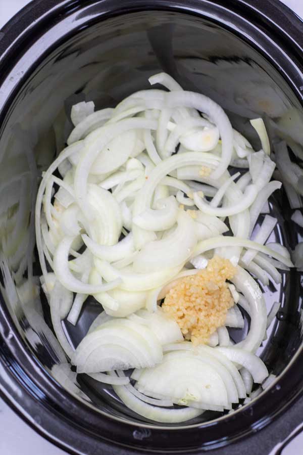 Process photo 1 add the sliced onions and minced garlic in your slow cooker.