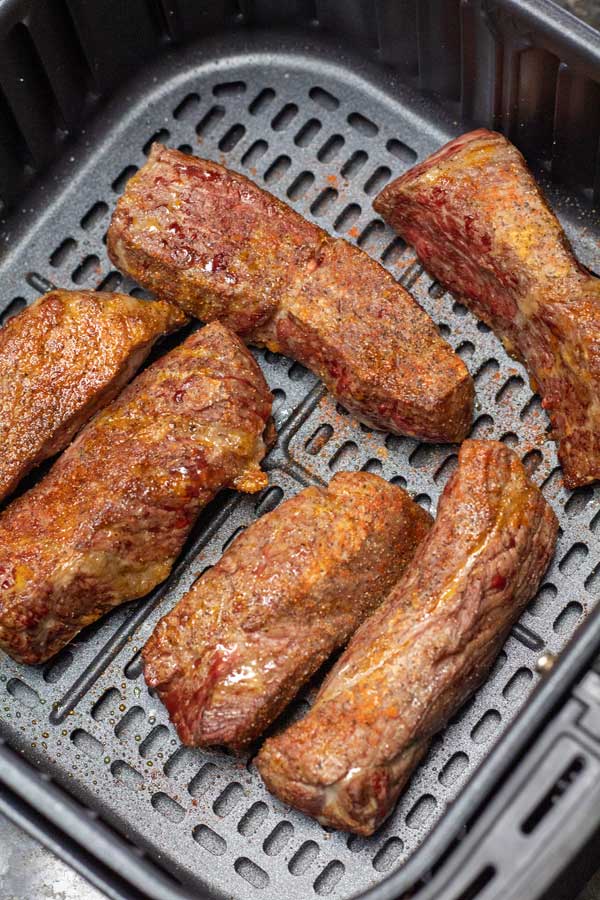Process photo 1 arrange the seasoned boneless country style beef ribs in your air fryer basket.
