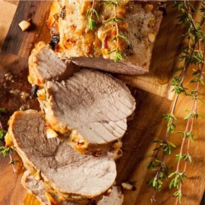 Pin image with text of pork tenderloin on a cutting board.