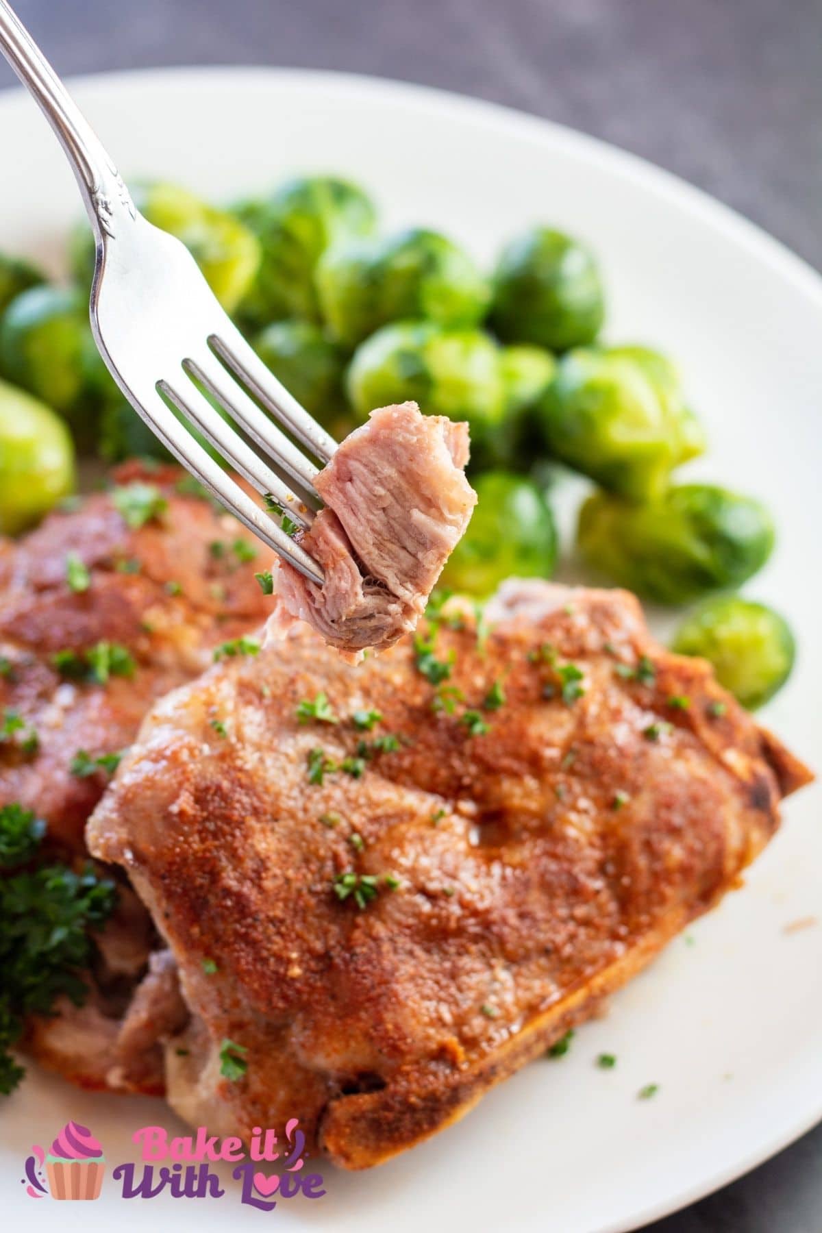 Tall image of country style pork loin chops on a white plate.