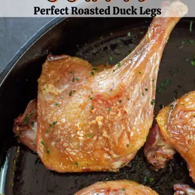 Pin image with text overlay of duck confit in a cast iron pan.