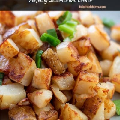 Pin image with text of duck fat fried potatoes topped with green onion on a plate.