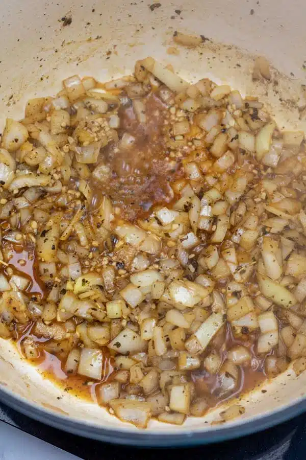 Process image 3 showing onions sauteing in the dutch oven.