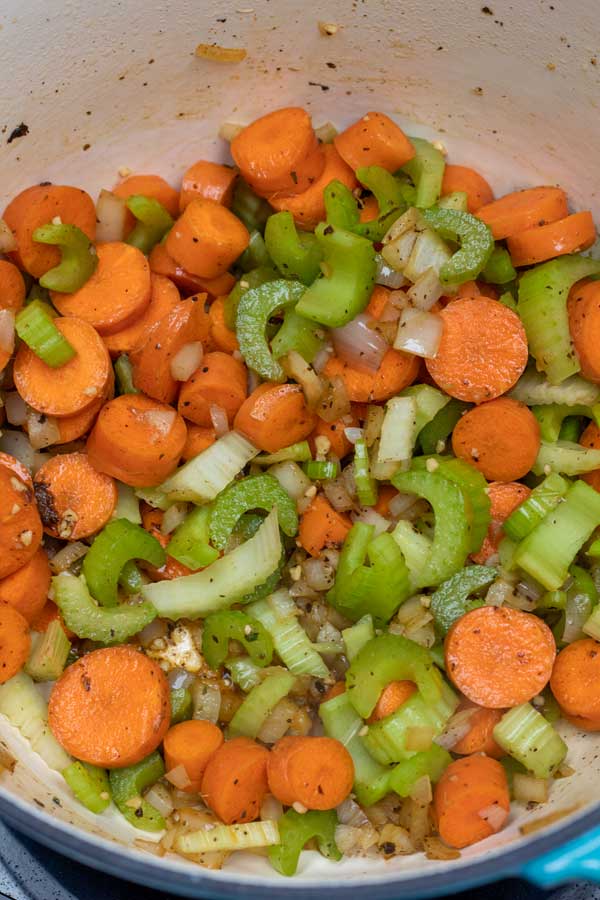 Process image 4 showing carrots and celery sauteing in the dutch oven.
