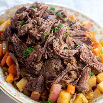 Square image of dutch oven pot roast plated.