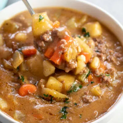 Square image of a white bowl of ground beef stew.