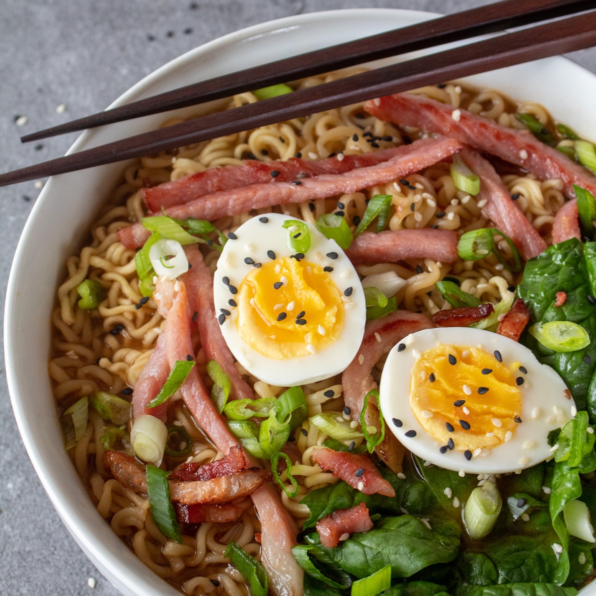 Square image of ramen noodles with leftover ham and hard boiled eggs.