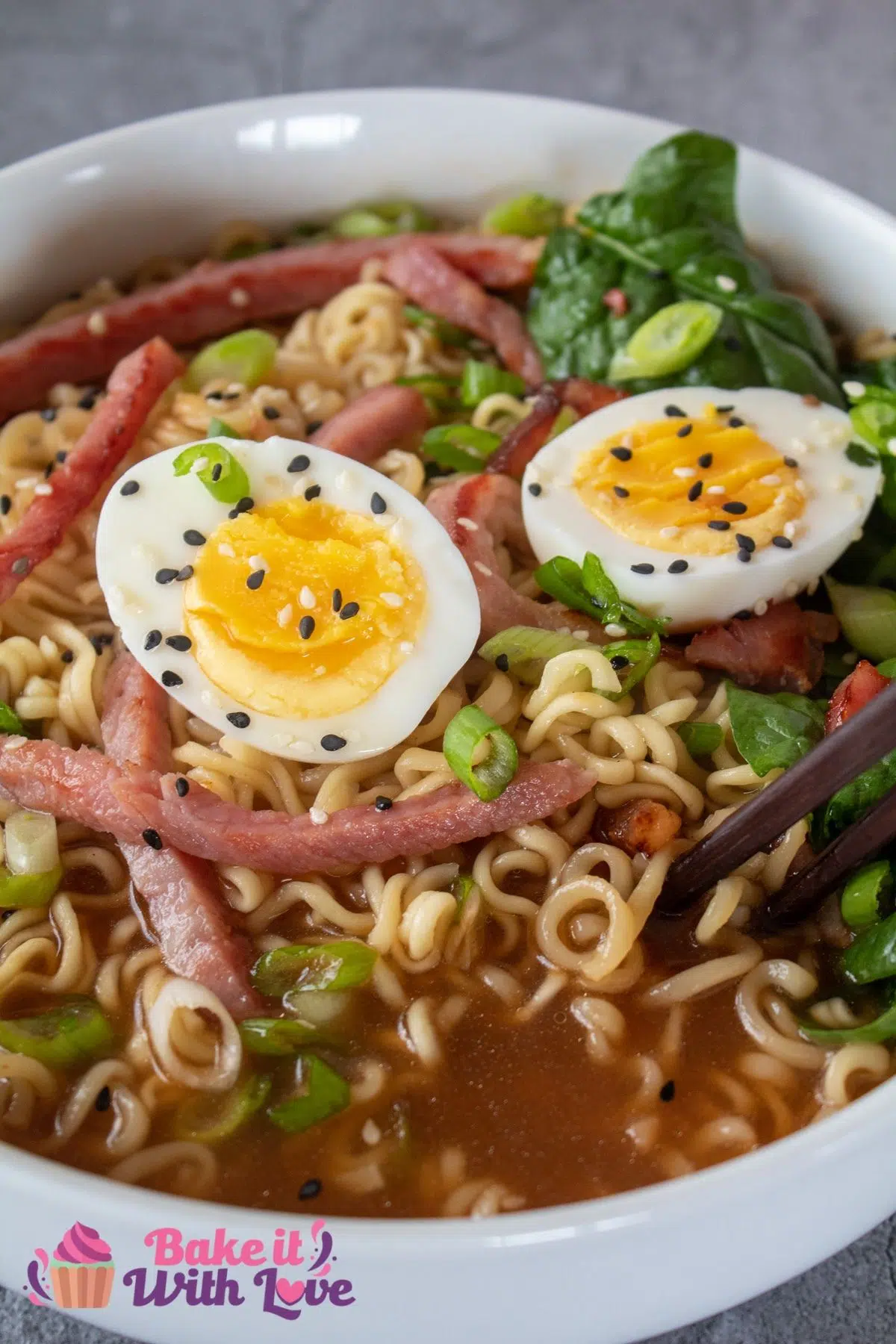 Tall image of ramen noodles with leftover ham and hard boiled eggs.